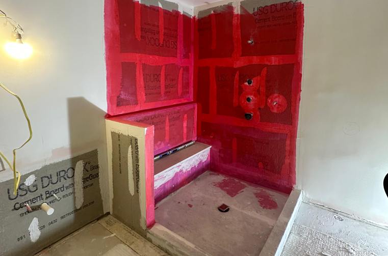 Shower bench and curb waterproofed in red membrane before tiling