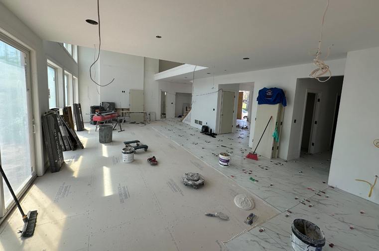 Open room under construction with bare subfloor before tiling