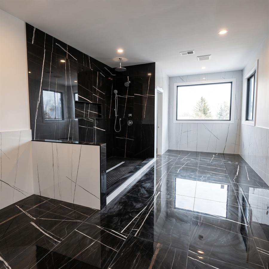 Black and white marble bathroom with glass shower enclosure, New Jersey