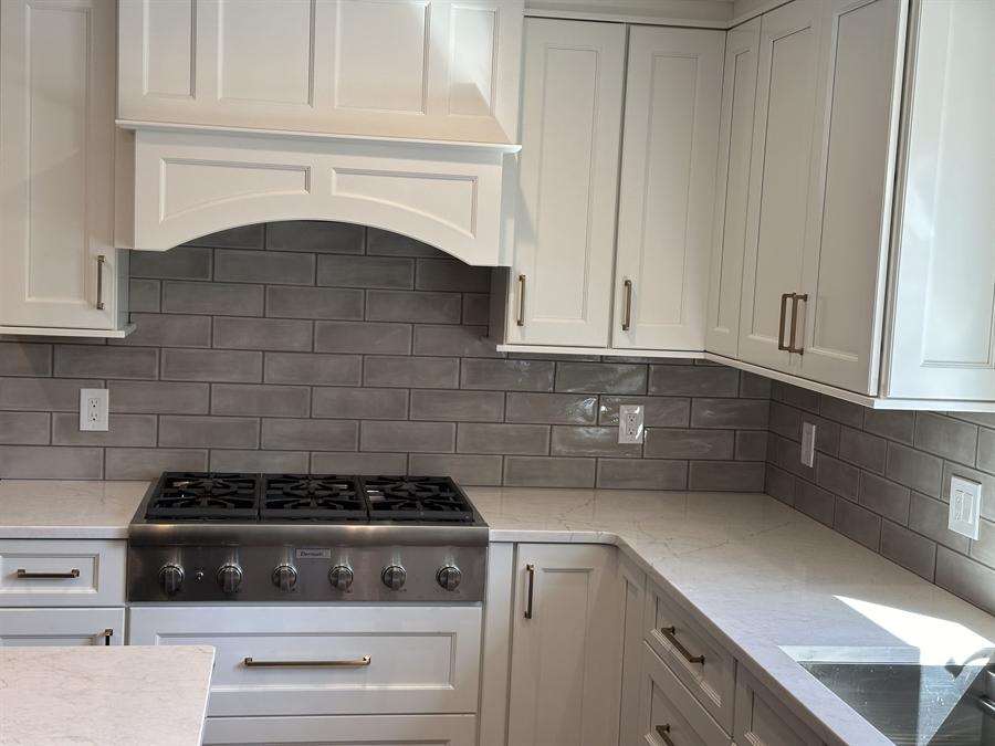 Kitchen with herringbone mosaic backsplash behind a pro range by Silcam Tile Installation, New Jersey