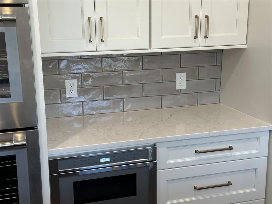 White kitchen with beveled subway tile backsplash and wall oven, New Jersey