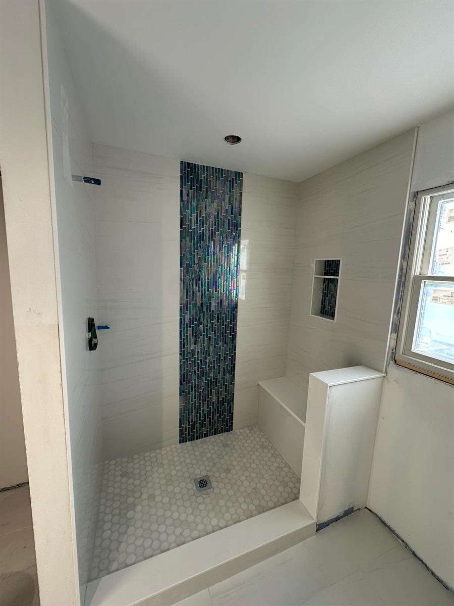 White tiled bathroom with vertical blue mosaic accent band, New Jersey
