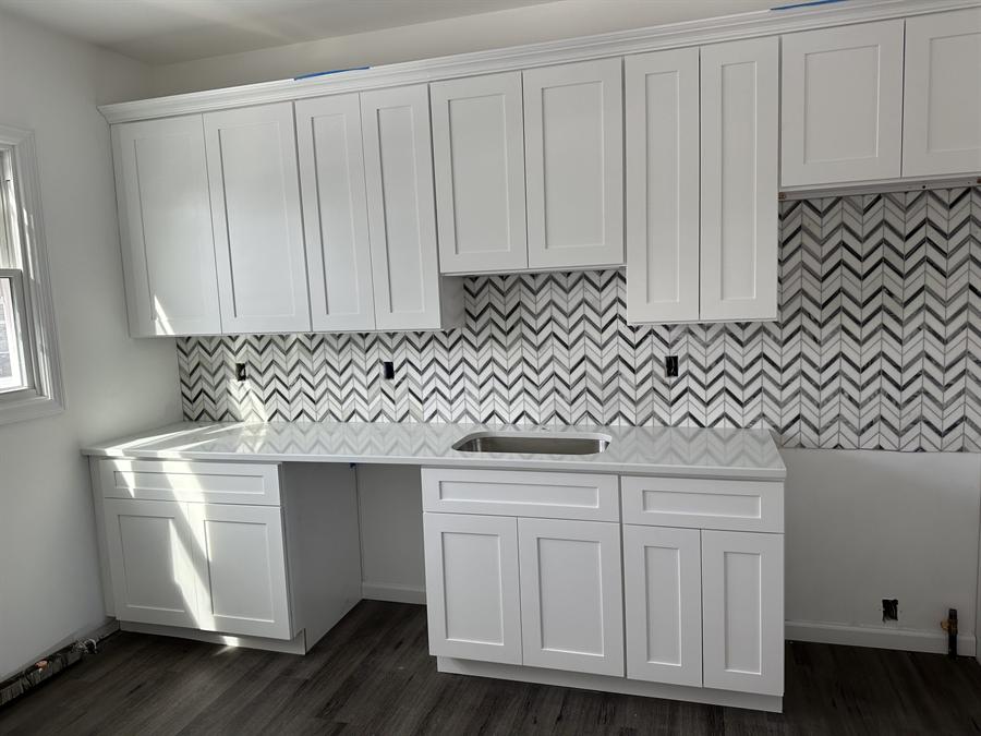 White kitchen with chevron marble mosaic backsplash installed by Silcam Tile in New Jersey